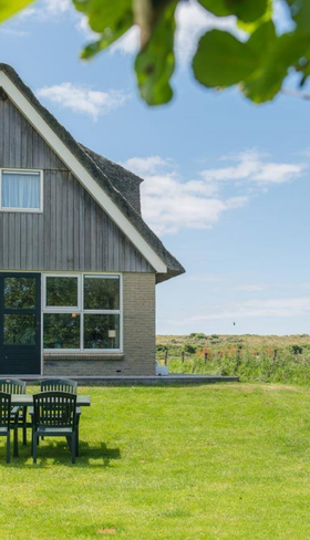 Luxe en vrijstaande vakantiewoning met rieten dak, gelegen in de duinen van Vakantiepark Boomhiemke op Ameland.