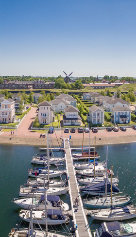 Luchtfoto van de bruisende jachthaven en de vakantiehuizen van Vakantiepark Cape Helius in Hellevoetsluis.