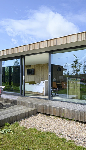 De buitenkant van een moderne vakantielodge met houten terras op de Pekelinge