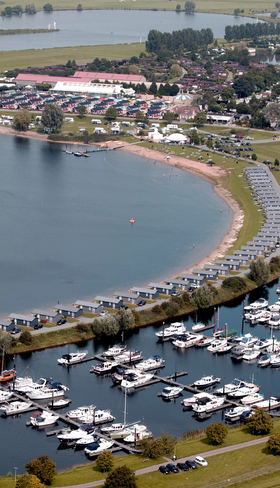 Luchtfoto van Vakantiepark Eiland van Maurik, gelegen aan een grote recreatieplas in Gelderland met een eigen zandstrand en jachthaven.