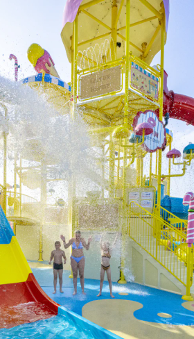 Een enorme emmer water kiept om over spelende kinderen in het waterpark