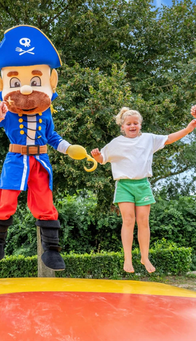 Kinderen springen samen met een mascotte op de grote airtrampoline