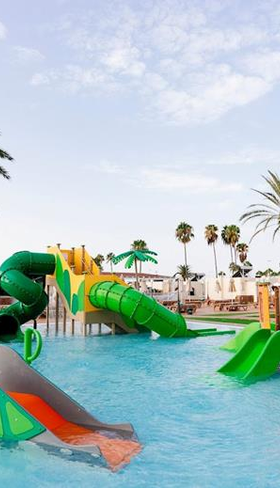 De kleurrijke waterspeeltuin van Parque Cristobal op Gran Canaria met diverse glijbanen en waterspuiters voor kinderen.