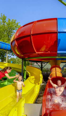 Kinderen glijden door de kleurrijke bochten van de grote waterglijbaan