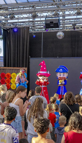 Kinderen kijken naar een spectaculaire show van het animatieteam op het podium