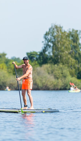Een man is aan het stand-up paddelen (suppen) op het Markermeer bij Vakantiepark Volendam.