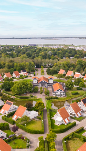 Luchtfoto van Vakantiepark Zeeland Village in Scharendijke, omringd door groen en gelegen nabij het Grevelingenmeer in Zeeland.