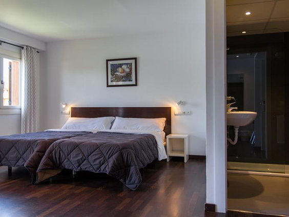 De slaapkamer in een van de appartementen van Albir Garden Resort, met twee opgemaakte bedden en een donkere houten vloer.