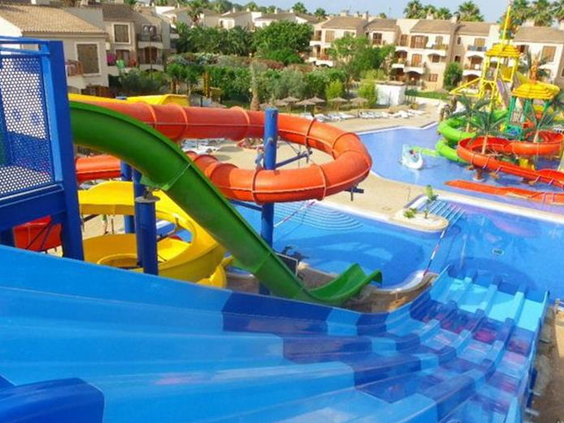 Een brede blauwe familieglijbaan met meerdere banen in het waterpark van Albir Garden Resort, waar je naast elkaar vanaf kunt glijden.