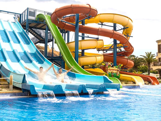 Kinderen glijden met veel waterpret van de brede, blauw-witte race-glijbaan in het aquapark van Albir Garden Resort aan de Costa Blanca.
