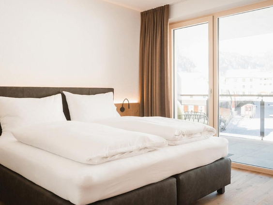 Moderne slaapkamer met tweepersoonsbed en balkon