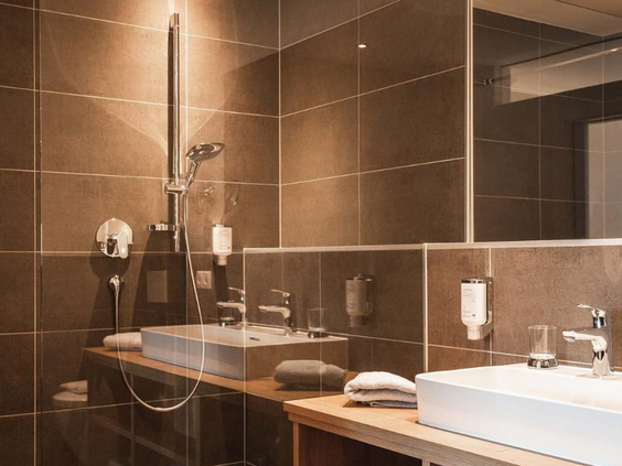 Moderne grijze badkamer met douche en wasbakken