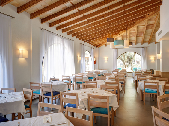 Het lichte en ruime restaurant interieur van Aparthotel Protur Safari Park op Mallorca, met een houten balkenplafond