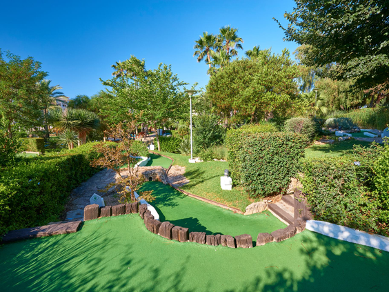 De uitdagende en groene minigolfbaan van Protur Safari Park op Mallorca, omgeven door bomen en struiken.