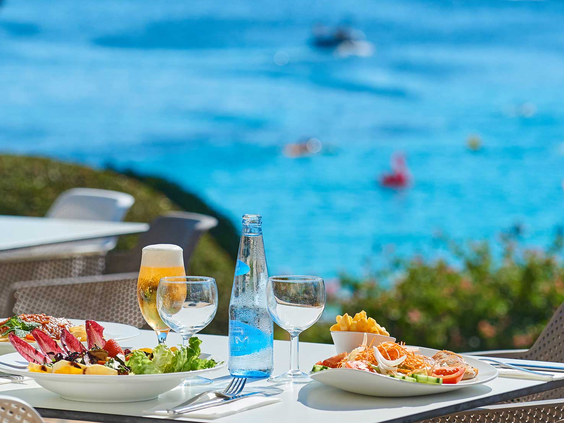 Een heerlijke lunch geserveerd op het terras van restaurant Inturotel Esmeralda Park, met een prachtig uitzicht over de helderblauwe zee.