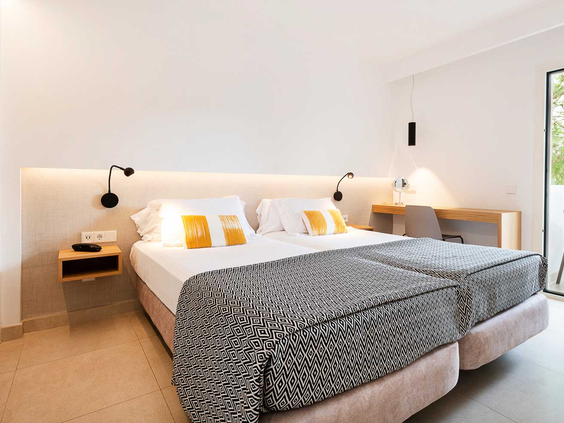 De lichte slaapkamer in een gerenoveerd appartement van Esmeralda Park, Mallorca, met comfortabele, opgemaakte bedden.