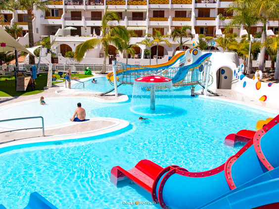 Het vrolijke kinderbad van Parque Santiago III op Tenerife met diverse kleine glijbanen en waterspeeltoestellen in het water.