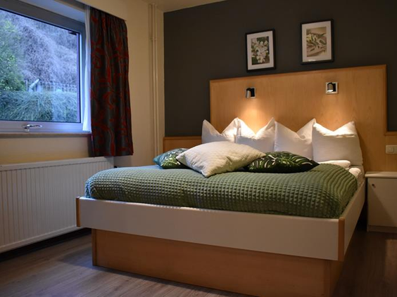 Moderne hotelkamer in Hotel Atlanta met een groen bed en een donkergrijze accentmuur