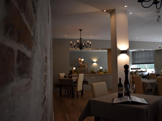 Chique restaurant in Hotel Atlanta met een rustieke bakstenen muur en een moderne inrichting in neutrale tinten