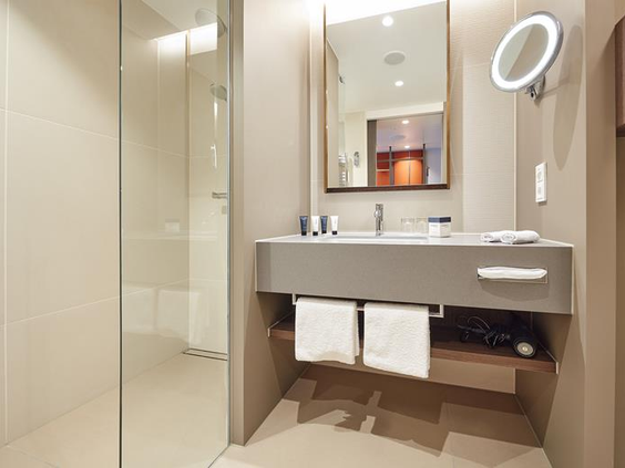 De moderne en luxe badkamer in het ATLANTIC Hotel Münster, voorzien van een ruime inloopdouche voor het hele gezin.