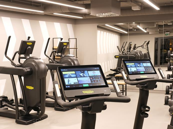 De moderne fitnessruimte van het ATLANTIC Hotel Münster met professionele apparatuur voor een complete workout.
