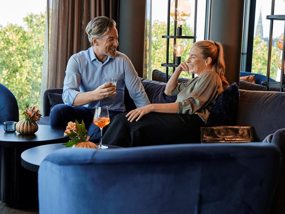 De sfeervolle skybar van het ATLANTIC Hotel Münster, waar gasten genieten van een drankje met een prachtig uitzicht over de stad.