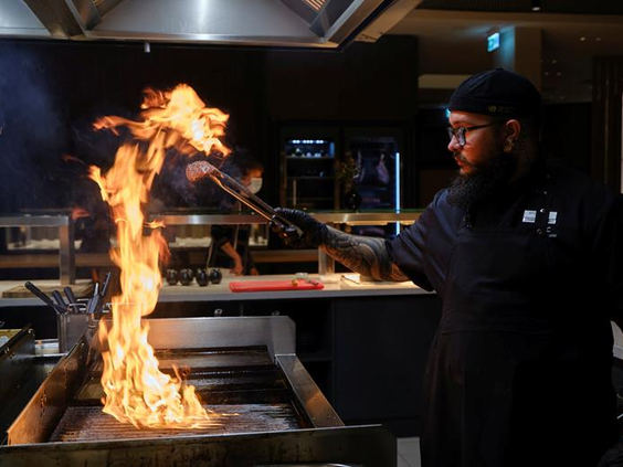 Show cooking bij de grill in het restaurant van het ATLANTIC Hotel Münster, waar gerechten spectaculair worden bereid.
