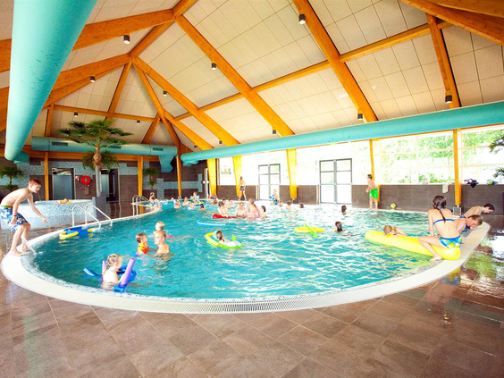 Het sfeervolle overdekte zwembad van Bad Hoophuizen, waar kinderen en gezinnen genieten van het water.