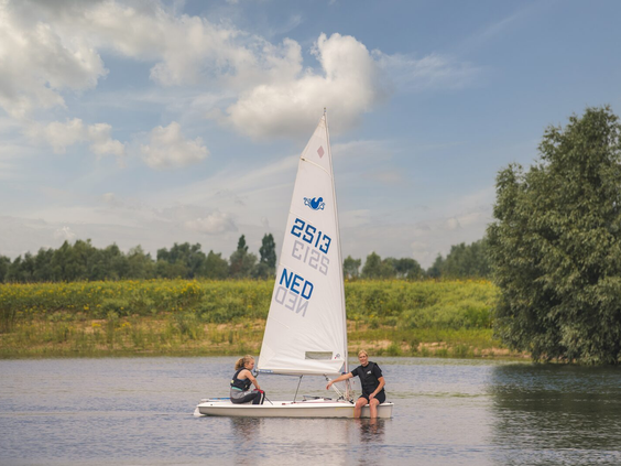 Een luxe, geschakelde vakantievilla met een oranje dak en een groene tuin op Vakantiepark Bad Nederrijn.