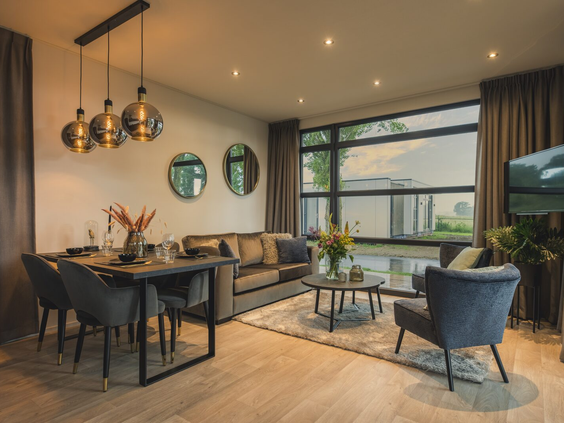 Modern en sfeervol interieur van een luxe vakantiewoning op Vakantiepark Bad Nederrijn, met een ruime woonkamer en eethoek.