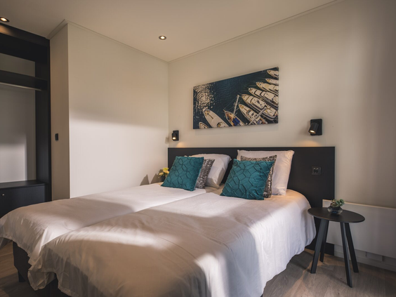Comfortabele slaapkamer met een opgemaakt tweepersoonsbed in een moderne vakantiewoning op Vakantiepark Bad Nederrijn.