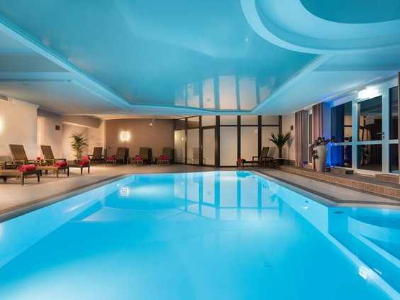 Het prachtig verlichte en ruime binnenzwembad van het Best Western hotel in Willingen, omringd door ligstoelen om te relaxen.
