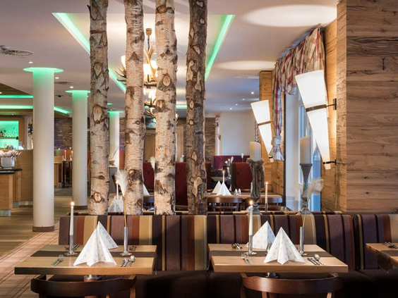 Het sfeervolle restaurant van het Best Western hotel met een modern interieur, versierd met natuurlijke elementen zoals berkenstammen.
