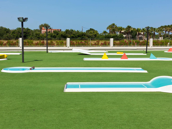 De vrolijke minigolfbaan van Blue Lagoon Resort, met groene kunstgras en kleurrijke hindernissen onder een strakblauwe lucht.