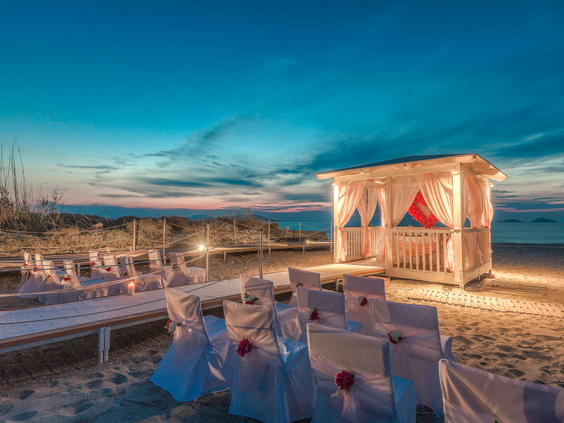 Een romantische trouwlocatie op het strand van Blue Lagoon Resort, sfeervol verlicht tijdens de zonsondergang.
