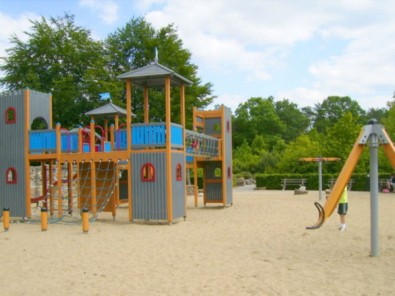 Het grote, houten klimkasteel in de ruime zandspeeltuin op Bospark De Schaapskooi, klaar voor avontuurlijke kinderen.