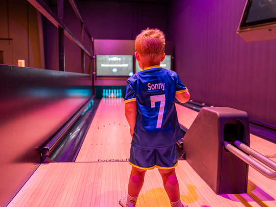 Jongetje gooit een bowlingbal op de kinderbowlingbaan in de Funzone van Bospark Ede.