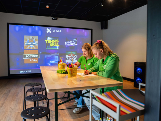 Kinderen zitten aan tafel in de recreatieruimte van Bospark Ede