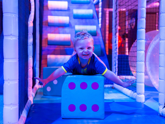 Lachend kind speelt met grote dobbelsteen in speelparadijs Bospark Ede