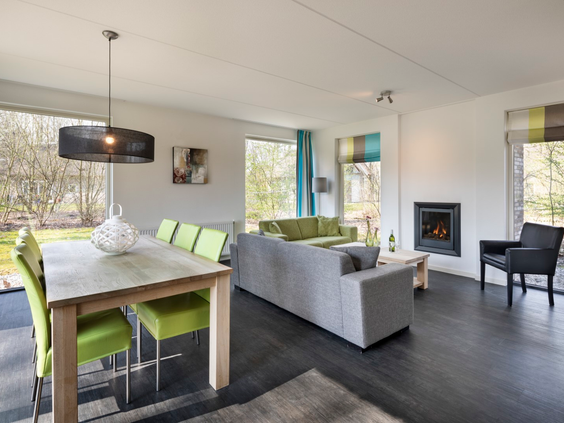 De gezellige woonkamer in een vakantieboerderij op Buitenplaats De Marke van Ruinen, met een comfortabele zithoek en een sfeervolle open haard.