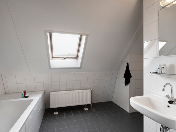 De lichte en moderne badkamer van een vakantiehuis op Buitenplaats De Marke van Ruinen, voorzien van een comfortabel ligbad.