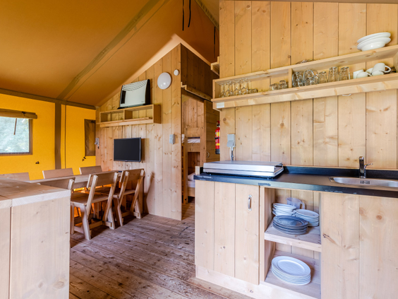 Houten interieur met keuken en eethoek van een luxe safaritent op bungalowpark De Katjeskelder.