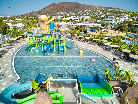 Luchtfoto van het kleurrijke kinderbad en de waterspeeltuin in het Aqualava Waterpark, met diverse glijbanen en speeltoestellen.
