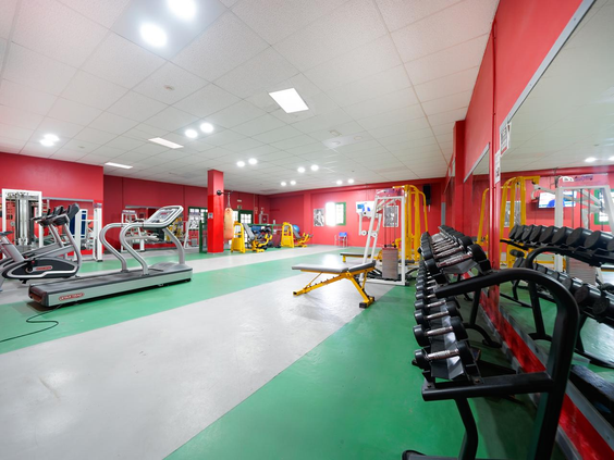 De ruime fitnessruimte van Relaxia Lanzasur Club, uitgerust met diverse cardio-apparaten, krachttrainingstoestellen en gewichten.