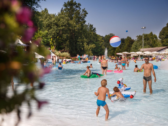 Kinderen en ouders die samen spelen met een bal in het ondiepe, kindvriendelijke zwembad van Camping Altomincio Family Park.