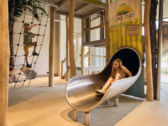 Een meisje glijdt van de metalen glijbaan in Speel- en Avonturenparadijs Ganvie op Camping Beekse Bergen.
