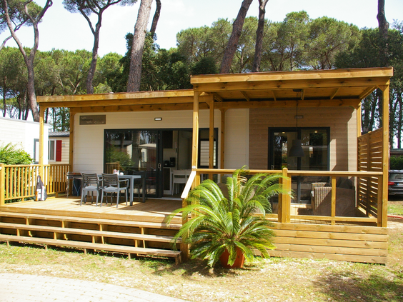 Moderne, luxe stacaravan met een grote houten veranda op camping Bella Italia.