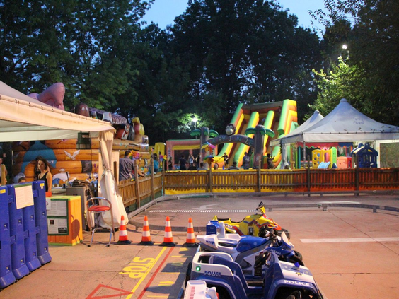 Avondvermaak op camping Bella Italia met kermisattracties zoals een springkussen en skelters.