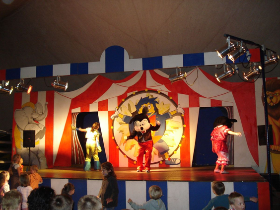 Avondshow voor kinderen met mascottes op een circuspodium op camping Bella Italia.