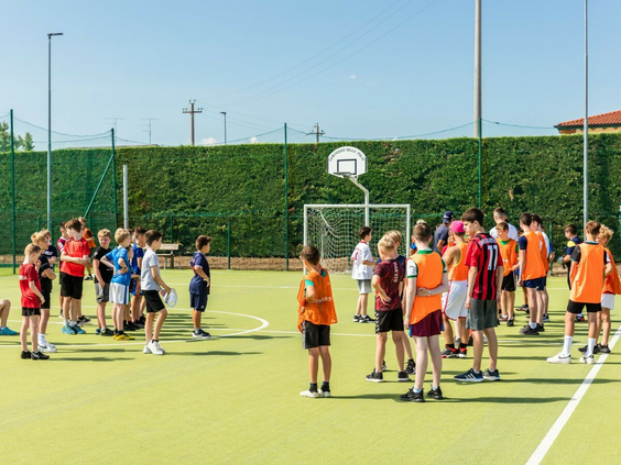 Kinderen doen mee aan een voetbaltoernooi georganiseerd door het animatieteam op het sportveld.